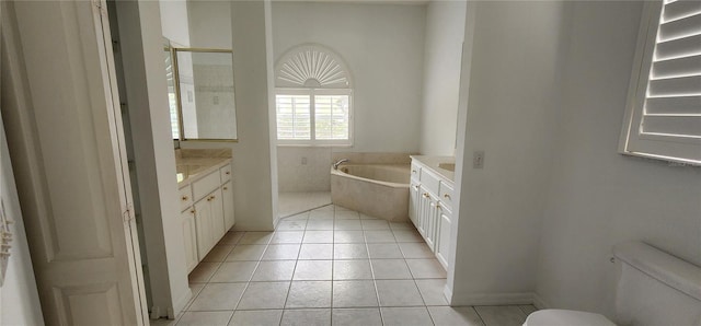 bathroom with tile patterned flooring, toilet, vanity, and a bath