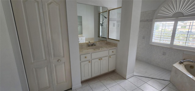 bathroom with a bath, a tile shower, vanity, and tile patterned floors