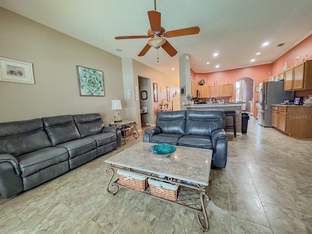 living room with ceiling fan, arched walkways, and recessed lighting