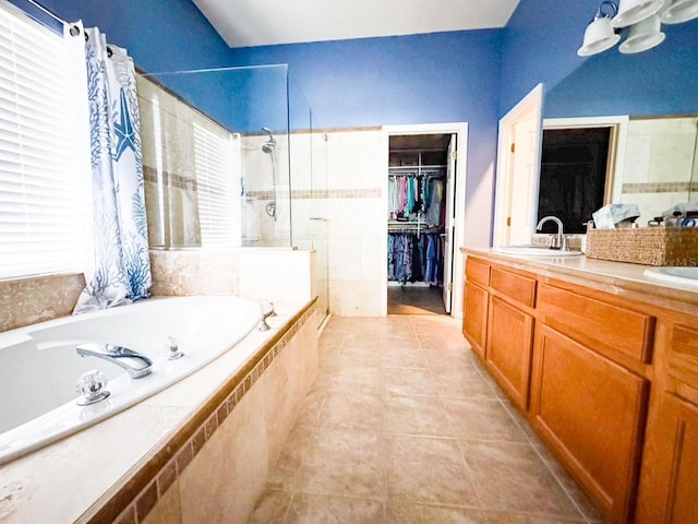 full bathroom with double vanity, a sink, a shower stall, a bath, and tile patterned floors