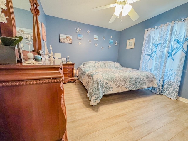 bedroom with baseboards, ceiling fan, and light wood finished floors