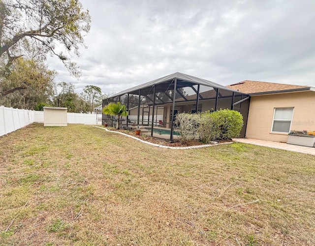 view of yard featuring glass enclosure, a fenced backyard, a storage shed, an outdoor structure, and an outdoor pool