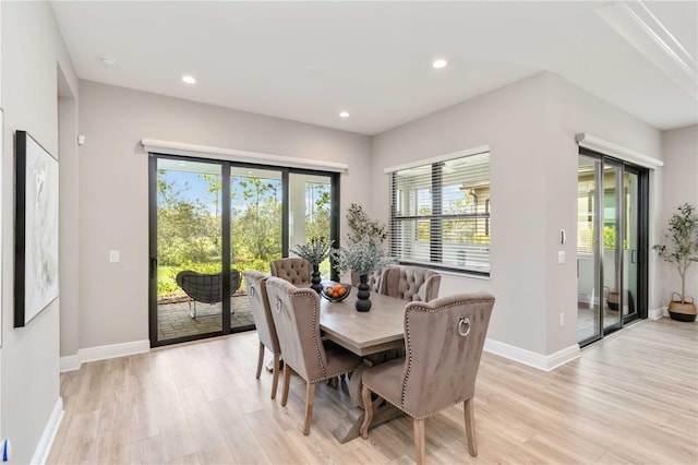 dining area with baseboards, light wood-type flooring, and recessed lighting