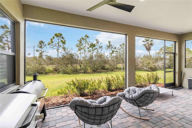 sunroom / solarium featuring ceiling fan