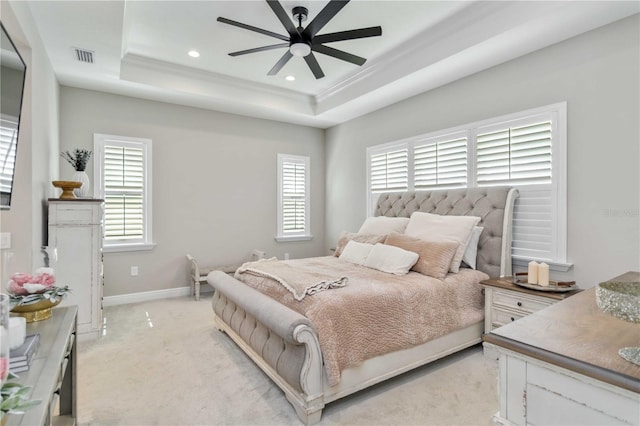 bedroom with a tray ceiling, recessed lighting, ornamental molding, light carpet, and baseboards