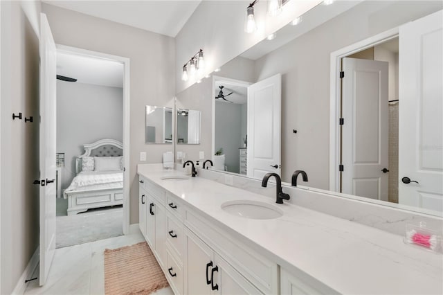 ensuite bathroom with double vanity, marble finish floor, a sink, and ensuite bathroom