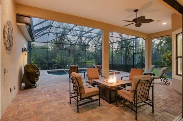 view of patio with an outdoor fire pit, glass enclosure, and a grill