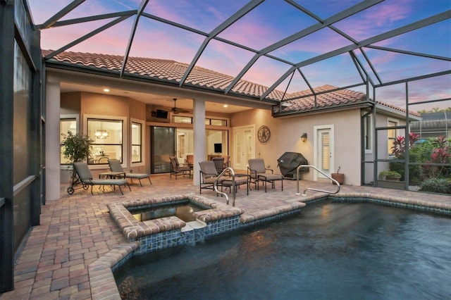 back of property featuring a tile roof, stucco siding, a patio area, ceiling fan, and an in ground hot tub