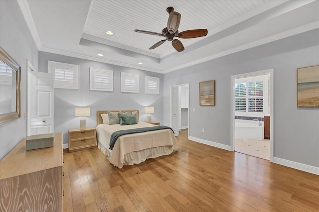 bedroom with recessed lighting, baseboards, a tray ceiling, light wood finished floors, and crown molding