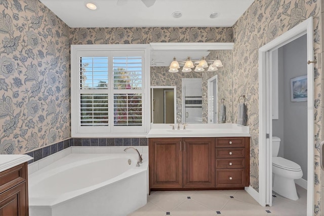 full bathroom featuring toilet, vanity, a bath, and wallpapered walls