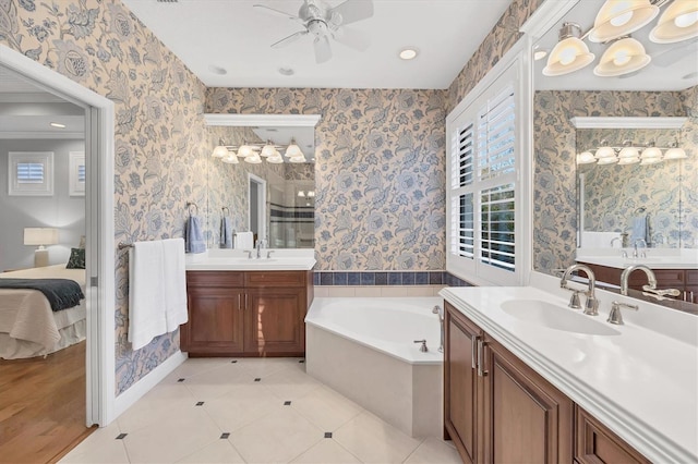 bathroom with a stall shower, a sink, and wallpapered walls