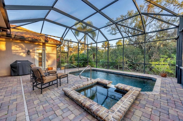 view of swimming pool featuring glass enclosure, a patio area, a grill, and a pool with connected hot tub