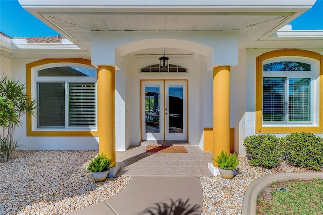 property entrance with stucco siding and french doors