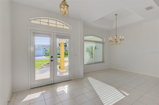 tiled entrance foyer featuring visible vents, baseboards, french doors, a notable chandelier, and a raised ceiling