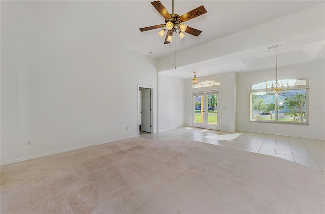 tiled spare room featuring visible vents, ceiling fan with notable chandelier, french doors, carpet flooring, and baseboards