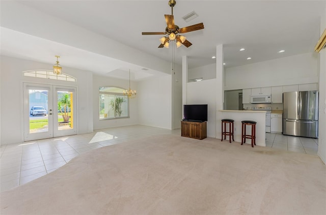 unfurnished living room featuring light tile patterned floors, visible vents, recessed lighting, french doors, and light carpet