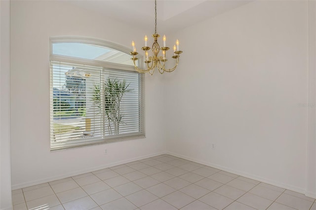 empty room featuring baseboards and an inviting chandelier