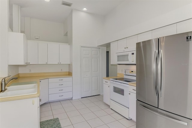 kitchen featuring white appliances, visible vents, a sink, light countertops, and white cabinetry