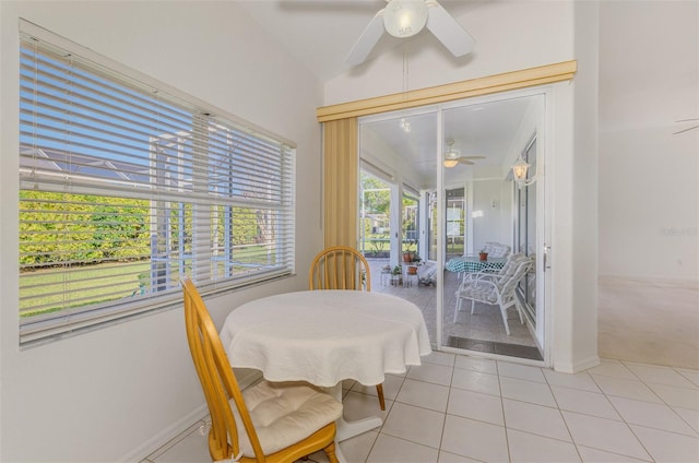 dining space with light tile patterned flooring, a ceiling fan, and baseboards