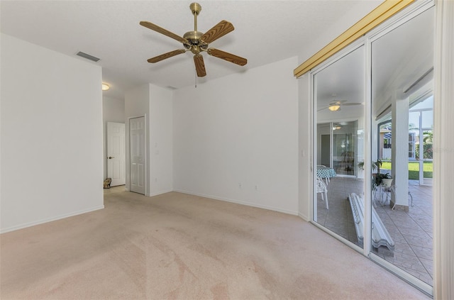 spare room featuring visible vents, carpet flooring, baseboards, and a ceiling fan