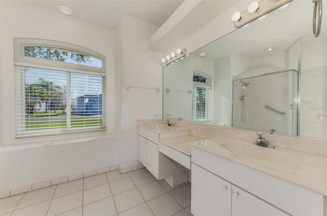 bathroom with tile patterned floors, baseboards, a stall shower, and vanity