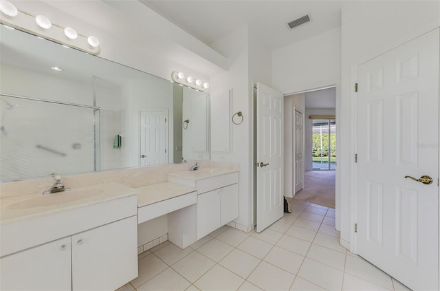 bathroom featuring visible vents, double vanity, a sink, tile patterned floors, and a shower with door