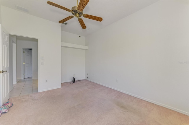 unfurnished bedroom with light tile patterned floors, visible vents, baseboards, ceiling fan, and light colored carpet