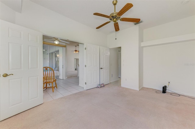 tiled spare room featuring baseboards, ceiling fan, and carpet flooring