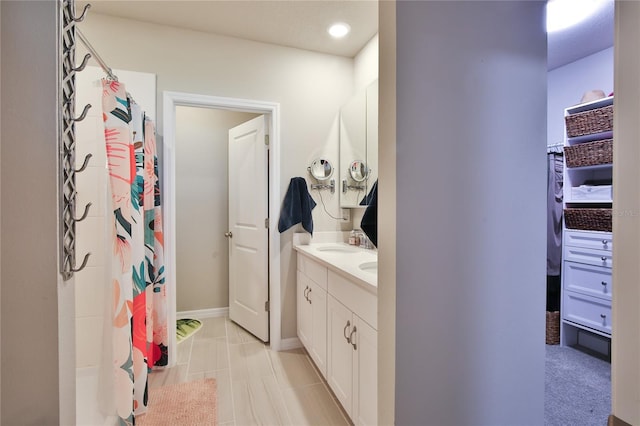 full bath with a shower with shower curtain, tile patterned flooring, baseboards, and vanity