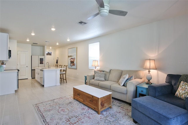 living room with ceiling fan, baseboards, visible vents, and recessed lighting