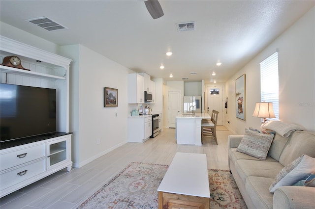 living room with ceiling fan, recessed lighting, visible vents, and baseboards