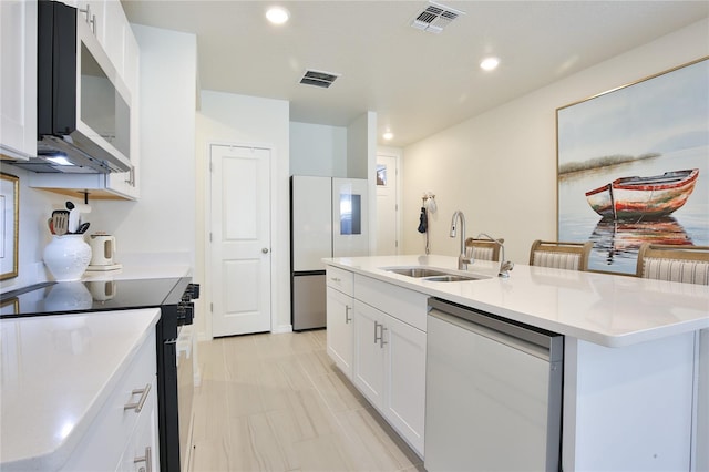 kitchen featuring visible vents, appliances with stainless steel finishes, a kitchen island with sink, white cabinetry, and a sink