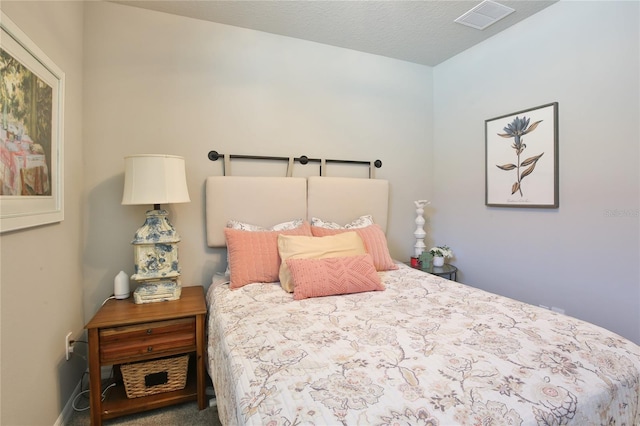 bedroom with a textured ceiling, carpet floors, and visible vents