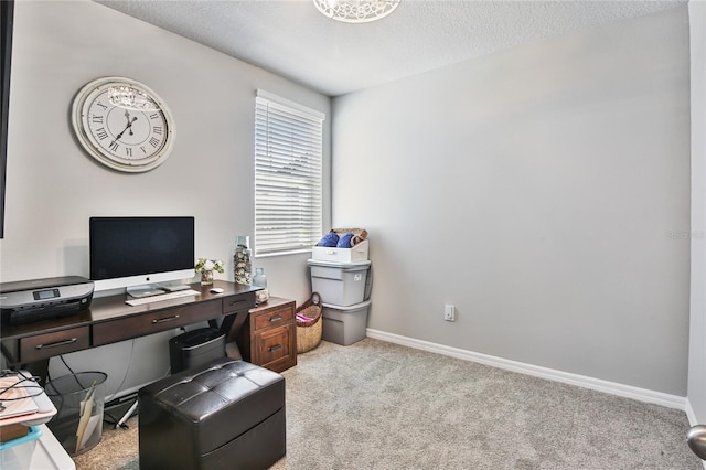 office space with baseboards, a textured ceiling, and light colored carpet