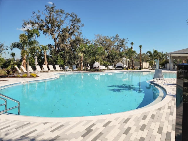 community pool with fence and a patio