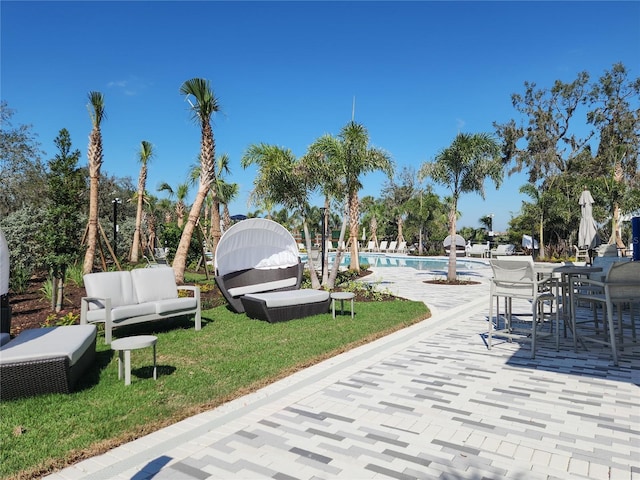 surrounding community featuring a pool, a patio area, and an outdoor living space