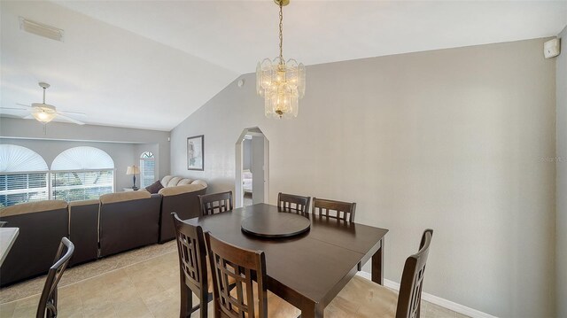 dining room featuring arched walkways, lofted ceiling, ceiling fan with notable chandelier, visible vents, and baseboards