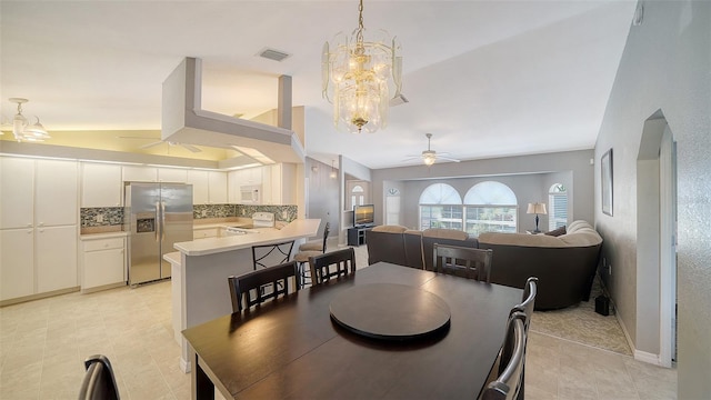 dining room featuring lofted ceiling, baseboards, visible vents, and ceiling fan with notable chandelier