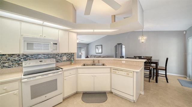 kitchen with light countertops, decorative backsplash, a sink, white appliances, and a peninsula