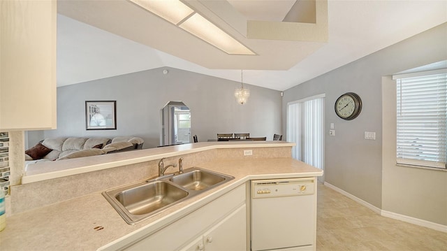 kitchen featuring lofted ceiling, hanging light fixtures, white dishwasher, light countertops, and a sink