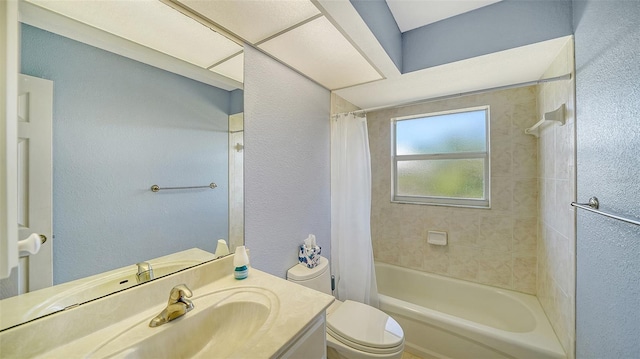 bathroom featuring shower / bath combo, a textured wall, vanity, and toilet