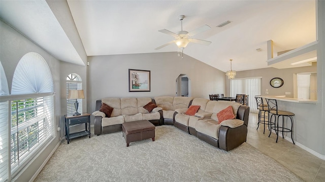 living area with light tile patterned floors, visible vents, baseboards, ceiling fan, and vaulted ceiling