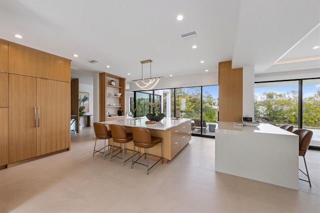 kitchen featuring visible vents, modern cabinets, open shelves, a kitchen breakfast bar, and light countertops