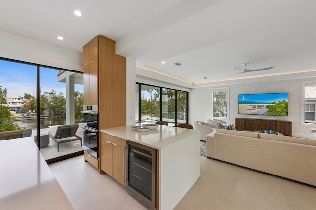 kitchen with modern cabinets, light countertops, beverage cooler, and stainless steel double oven