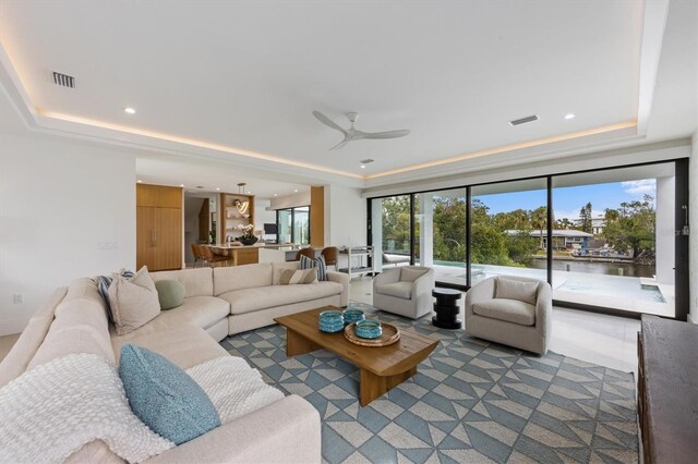 living room featuring visible vents, recessed lighting, and a tray ceiling