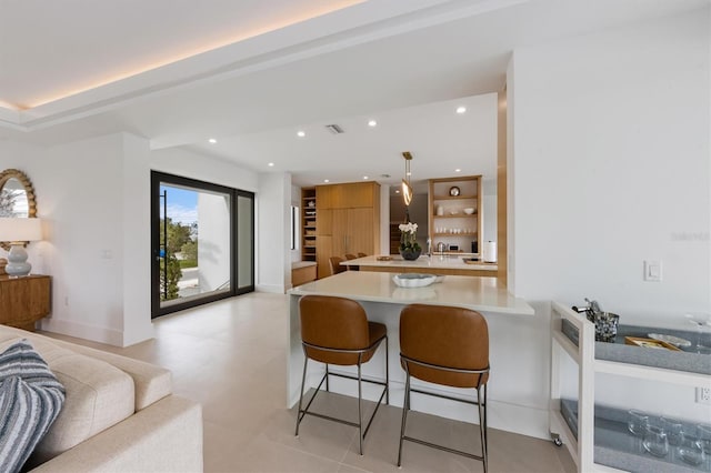 kitchen with visible vents, a breakfast bar, recessed lighting, a peninsula, and light countertops