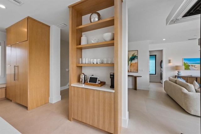 kitchen with built in shelves, visible vents, light countertops, modern cabinets, and open floor plan