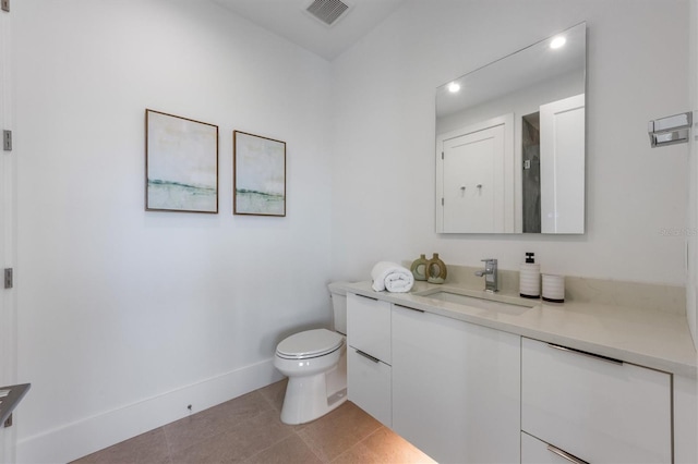 bathroom with vanity, baseboards, visible vents, tile patterned floors, and toilet