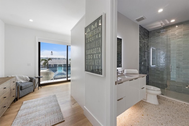 bathroom with visible vents, a stall shower, vanity, and wood finished floors