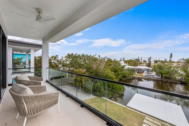 balcony featuring a water view and a ceiling fan